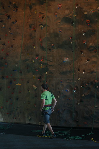 A belayer in front of the rock wall at the Bridges Center A belayer in front of the rock wall at the Bridges Center