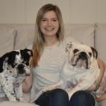 woman sitting on couch with two bulldogs