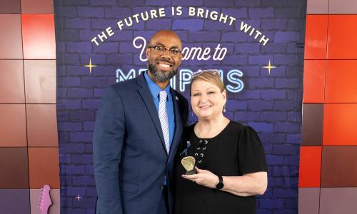man and woman posting together holding a golden tropy