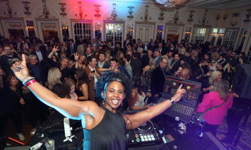 DJ poses for photo in front of crowd at Peabody NYW
