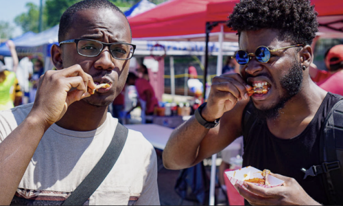 two men eating hot wings