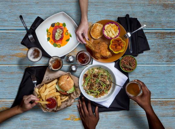 Hands reaching for food on a table