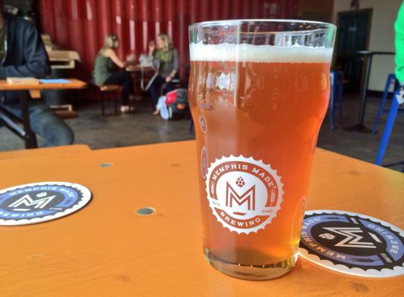 a glass of amber-colored beer in a glass in a brewery taproom