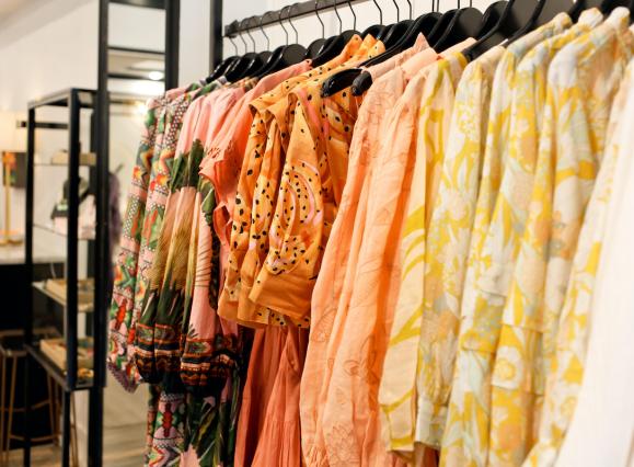 row of colorful warm colored blouses at boutique