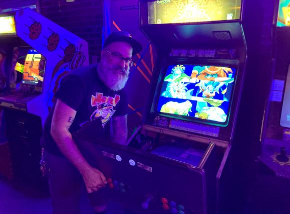 man fixing a video game at an arcade