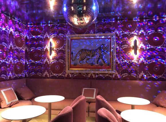 pink lit lounge room with disco ball and seating