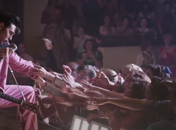 elvis reaching down to touch hands of crowd