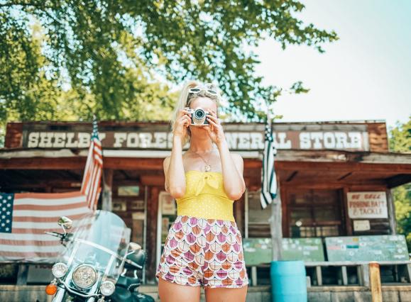 Girl snapping a photo in front of Shelby Forest General Store in Millington near Memphis | Oui We Girl