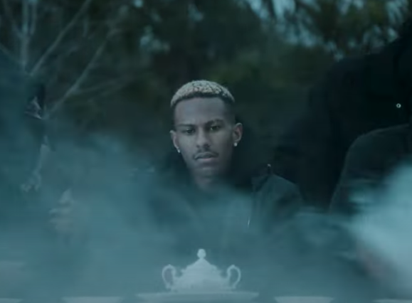 screen shot of music video man at table in the fog