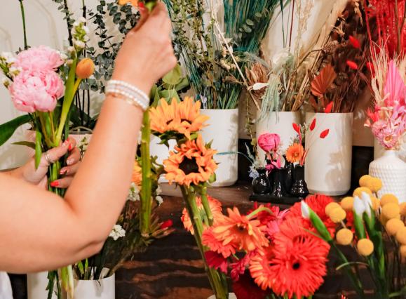 hand reaching for sunflower in bouquet wall
