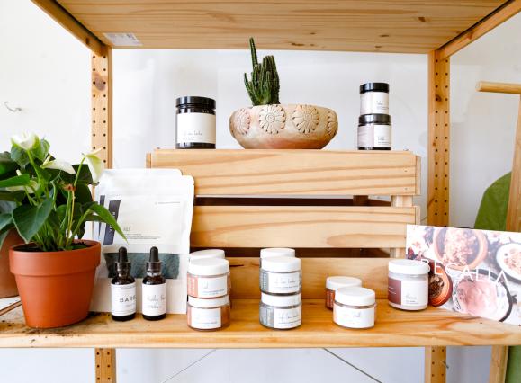 wooden shelf with body products in jars and a plant
