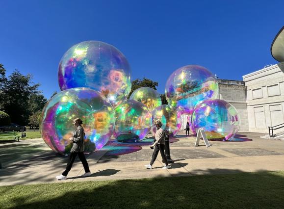 people walking on plaza with plastic bubbles