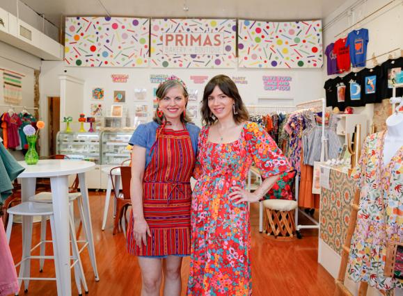 Two women standing in brightly lit shop