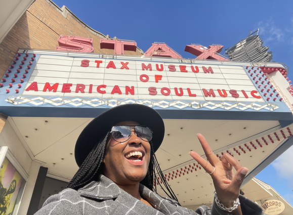Tiffani smiles with a peace sign in front of Stax Museum of American Soul Music building sign