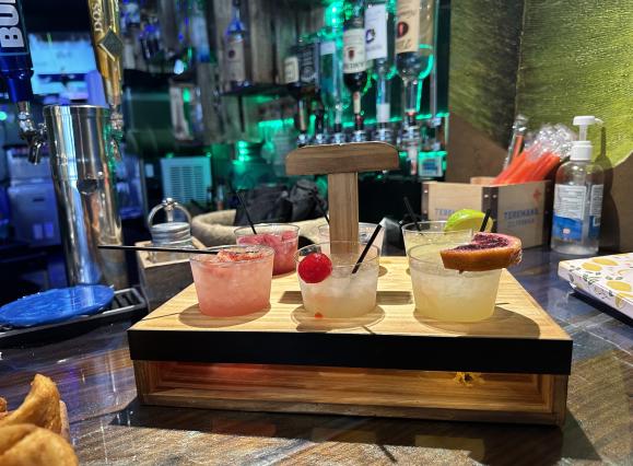 photo of margarita flight in container. six different drinks