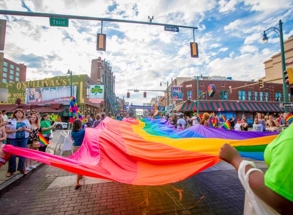 rainbow flag being walked down beale street during pride festival
