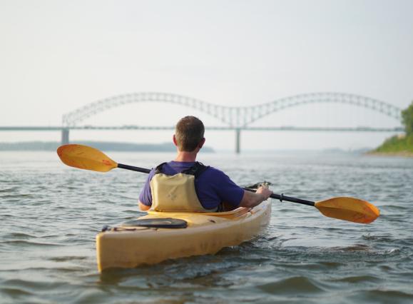 person kayaking on river
