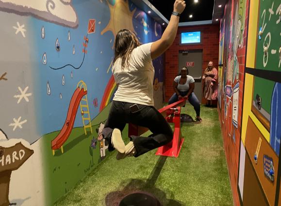 two girls on a see saw in themed room