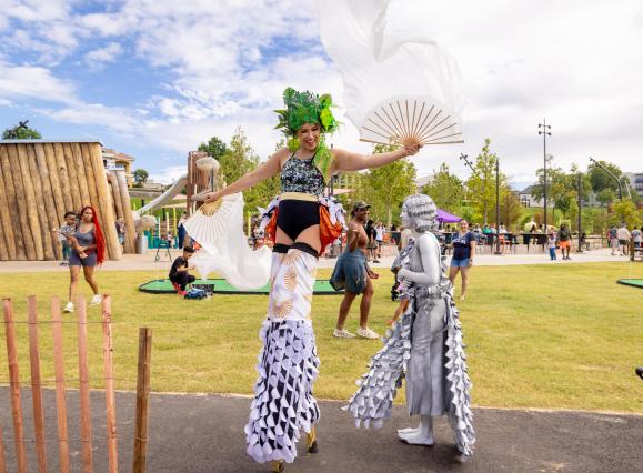 Tom Lee Park lady on stilts with colorful outfit on at the park