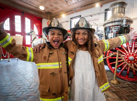 Two children dressed as firefighters at the Fire Museum of Memphis