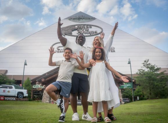 family poses in front of bass pro pyramid
