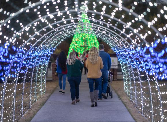 people walk through light tunnel