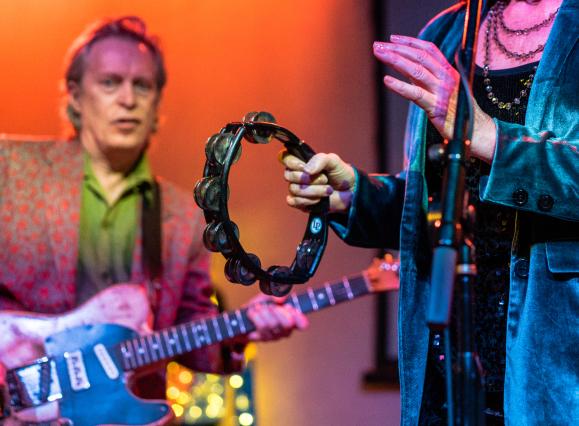 close up of band playing tambourine and guitar