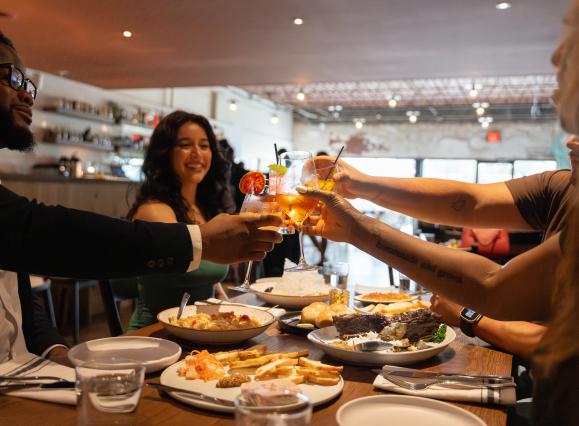 group of friends cheers drinks at dinner
