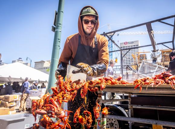 man pushes crawfish into bucket