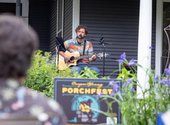 man plays guitar and sings during porchfest