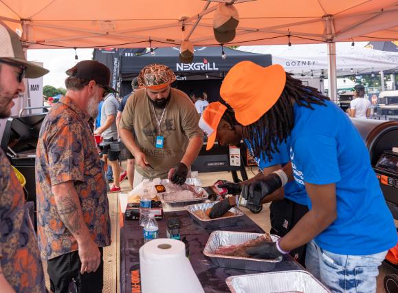 men prepare bbq for guests at world championship barbecue cooking contest