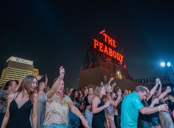 people dancing on peabody rooftop during rooftop party