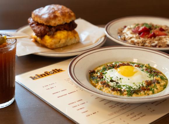 assortment of breakfast dishes: grits bowl, chicken biscuit sandwich over kinfolk menu