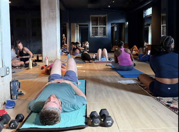 people rest on mats before pilates class
