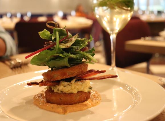 very tall sandwich with eggs, bacon, and lettuce 