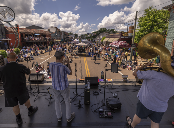 band plays on stage overlooking crowd at Overton Square Crawfish Festival