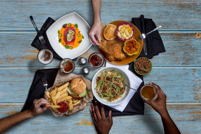 Hands reaching for food on a table