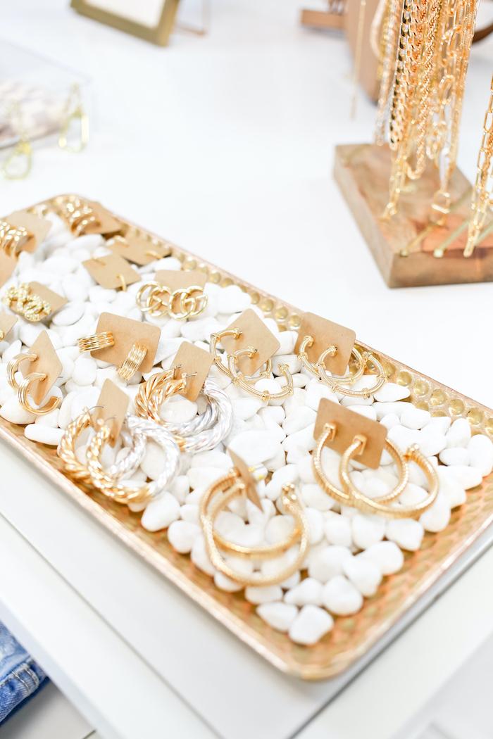 gold and silver hoop earrings on a gold and white tray