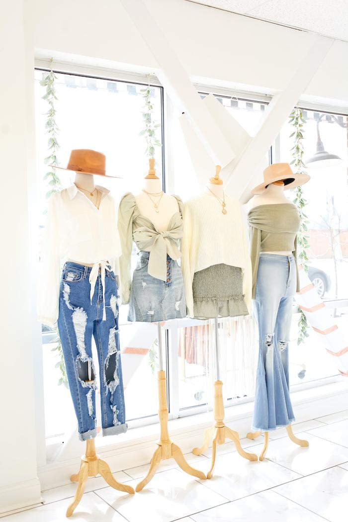 mannequins modeling jeans and feminine top in a brightly lit boutique