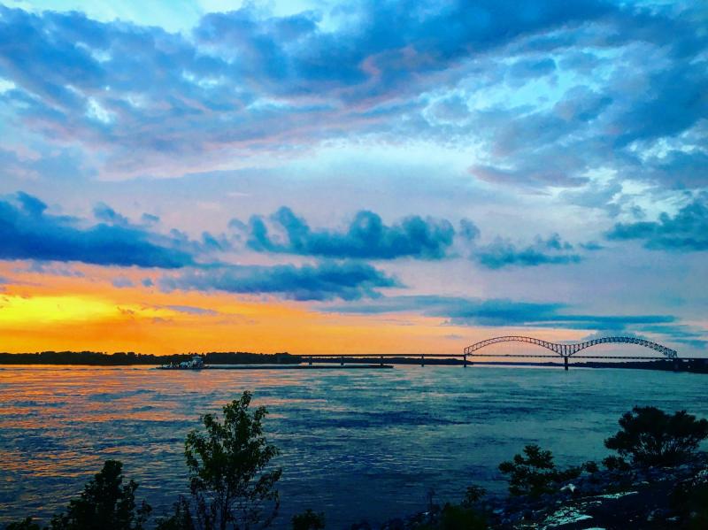 blue and orange sunset over MS River with double-arched bridge
