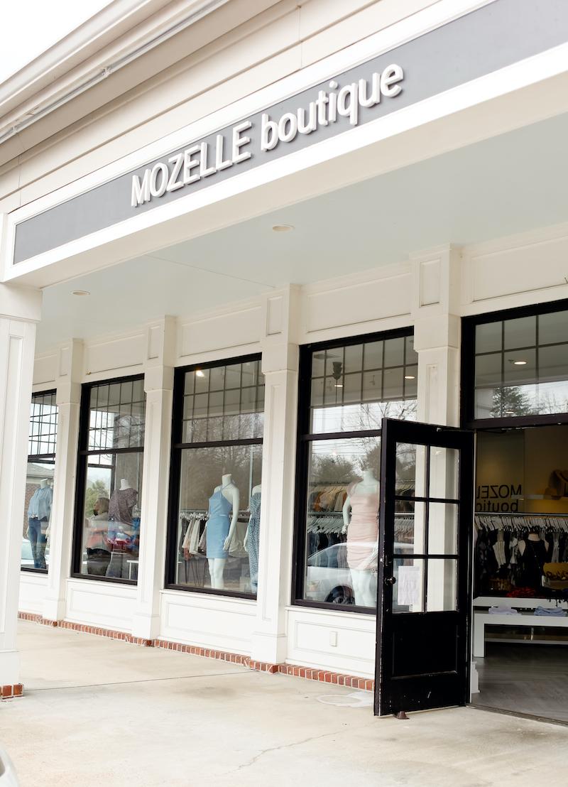 outside of Mozell boutique with white walls and window and a black door frame