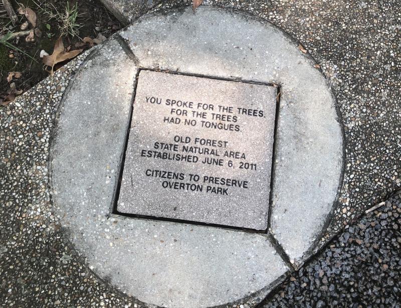 Circular concerte marker that says &quot;You Spoke For The Trees, For The Trees Had No Tongues&quot; at Overton Park