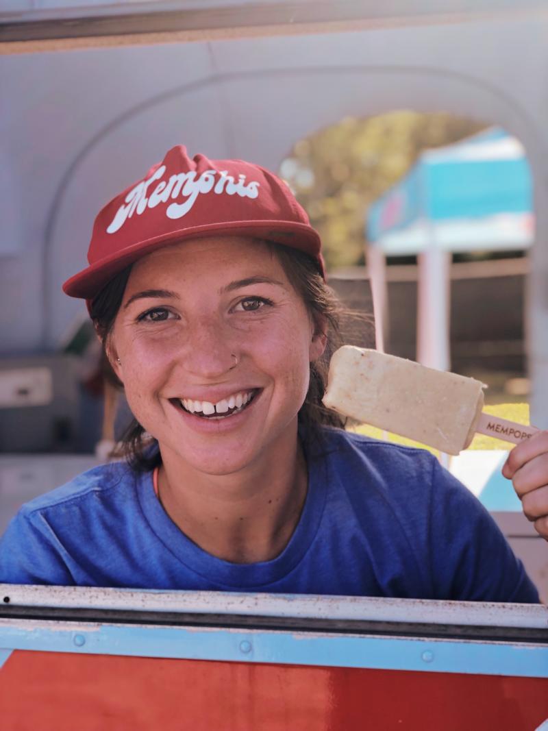 girl in red baseball cap smiling and holding a cream pop from MEMpops