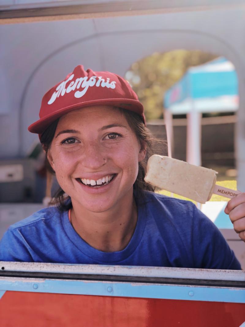 girl in red baseball cap smiling and holding a cream pop from MEMpops