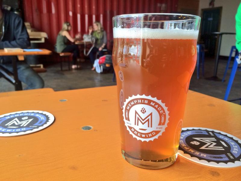 a glass of amber-colored beer in a glass in a brewery taproom