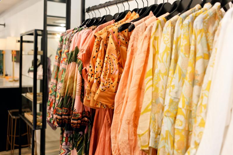 row of colorful warm colored blouses at boutique