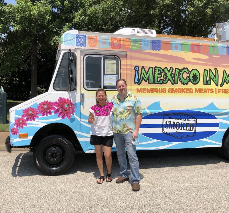 two people in front of colorful food truck