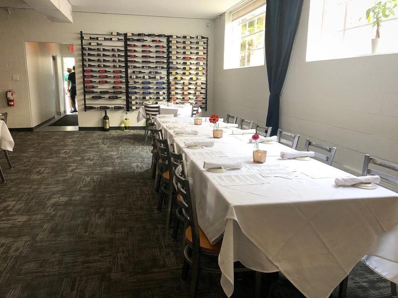 dining room with white tablecloth and wine rack on wall