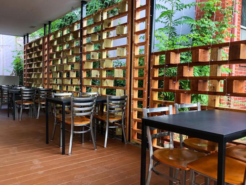 side patio with wood lattice work and tables