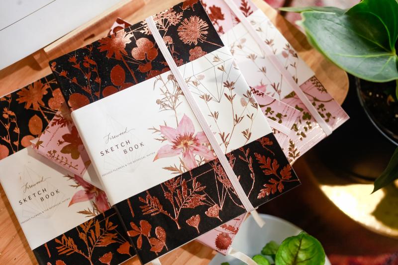 stack of sketchbooks with floral covers at gift shop